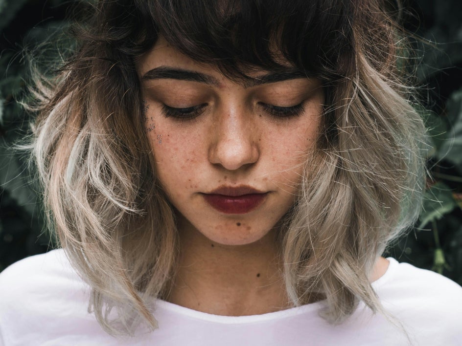 Before: close up portrait of woman with curly hair and garden background